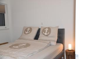 a bedroom with a bed with two pillows on it at Strandvilla GLOWE - Strandjuwel in Glowe