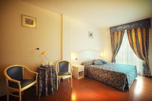 sypialnia z łóżkiem, dwoma krzesłami i stołem w obiekcie Hotel Vedute w mieście Fucecchio