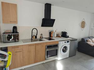 a kitchen with a sink and a washing machine at Le Cocon in Sermaises +5 photos