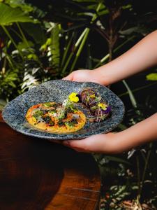 a person holding a plate of food on a table at Kapievi Ecovillage in Puerto Maldonado