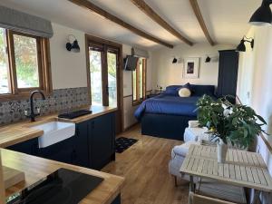 a kitchen and a living room with a bed in a room at Swifts Return Shepherd's Hut in North Lopham