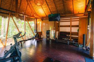 a gym with two treadmills and a television in a room at Kapievi Ecovillage in Puerto Maldonado