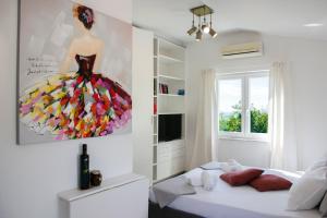 a bedroom with a painting of a woman on the wall at OleaVista in Portorož