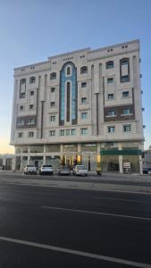 a large building with cars parked in front of it at شقق أون يسن للشقق المخدومة in Medina