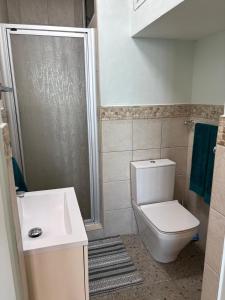 a bathroom with a shower and a toilet and a sink at Sea View Bliss in Ballito