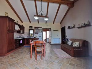 a kitchen and living room with a table and a couch at Casa La Dimora in SantʼAlfio +4 photos