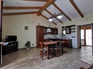 a large kitchen with a wooden table and chairs at Casa La Dimora in SantʼAlfio