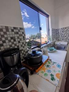 a kitchen with a counter with a pot and a window at GuestHouse Encanto del Centro 3 in Encarnación +9 photos
