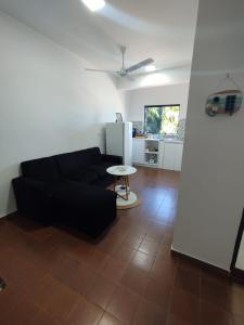 a living room with a black couch and a table at GuestHouse Encanto del Centro 3 in Encarnación