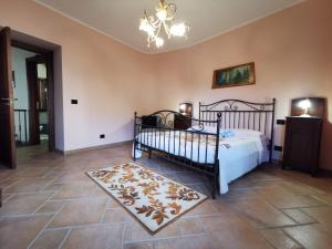 a bedroom with a bed and a rug and a chandelier at Casa La Dimora in SantʼAlfio