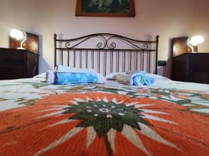 a bedroom with a large bed with an orange and white blanket at Casa La Dimora in SantʼAlfio