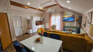 a living room with a couch and a table at Sunrise Riverside House-Private Garden, Jacuzzi & BBQ in Čelarevo