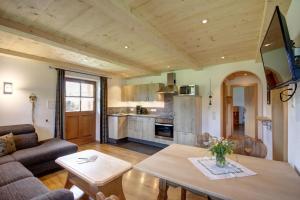 a living room with a couch and a table at Wimmerhof - Chiemgau Karte in Inzell