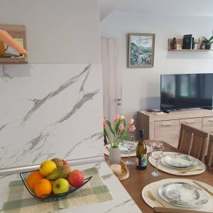 a table with a bowl of fruit and a television at Balkan Tower Elegance by K in Gabrovo
