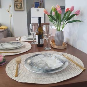 a table with plates and glasses and a bottle of wine at Balkan Tower Elegance by K in Gabrovo