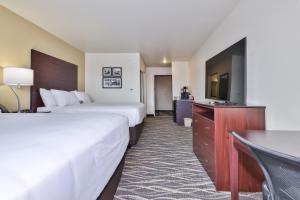 a hotel room with two beds and a flat screen tv at Cobblestone Hotel & Suites - Monte Vista in Monte Vista +1 photo