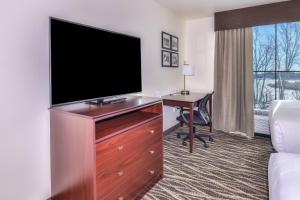 a hotel room with a flat screen tv and a desk at Cobblestone Hotel & Suites - Monte Vista in Monte Vista