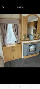 a kitchen with a microwave in a wooden cabinet at Promenade Betty's in Ingoldmells