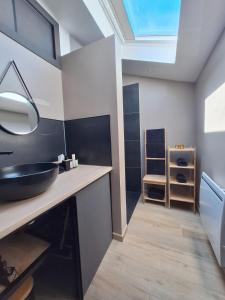a bathroom with a sink and a skylight at Gîte des binamés in Profondeville