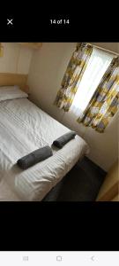 a bedroom with a bed with two pillows on it at Promenade Betty's in Ingoldmells