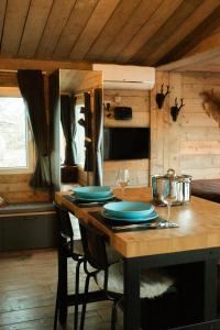 ein Holztisch mit Tellern und Weingläsern darauf in der Unterkunft Chalet WILD in Geel + 24 Fotos