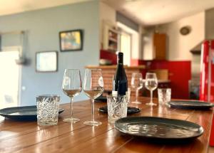 a table with a bottle of wine and glasses on it at Maison avec piscine et vue panoramique in Albi