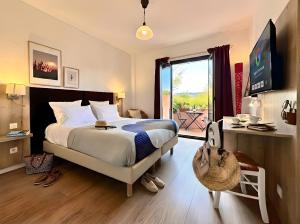 a bedroom with a large bed and a balcony at Hotel Le Provence - Restaurant Le Styx in La Palud-sur-Verdon