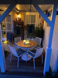a table and chairs on a porch at night at Gastenverblijf Het Groene Hart in Lanaken +27 photos