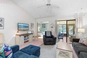 a living room with a couch and a tv at Sea Woods Villa 4263 in New Smyrna Beach