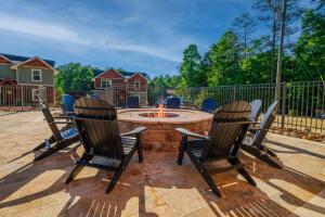 a patio with chairs and a fire pit at Bears Haven – Elegant 3 BR Chalet Game Area, Hot Tub, see through fire place in Gatlinburg