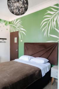 a bedroom with a bed with a green wall at The Secret Garden Hostel in Lima