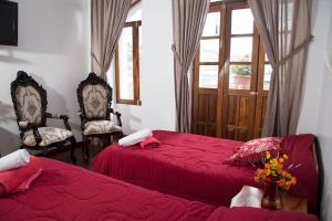 a bedroom with two beds and two chairs and a window at Hotel Plaza del Teatro in Quito +51 photos