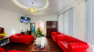 a living room with red couches and a tv at Hotel Plaza del Teatro in Quito