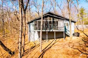 a small house in the middle of the woods at Massanutten Chalet View & Fire Table Deck in McGaheysville