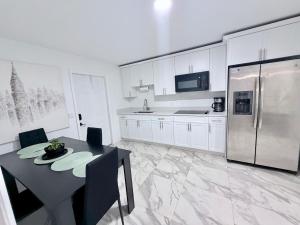 a kitchen with a table and a stainless steel refrigerator at 2 bed peaceful, lakeview studio NO FEES in Atlantis