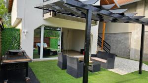 a pergola in the backyard of a house at Sunrise Riverside House-Private Garden, Jacuzzi & BBQ in Čelarevo