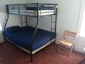 a bedroom with two bunk beds and a chair at Altgeld House in South Bend +1 photo