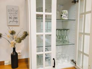 a white cabinet with glass shelves and a vase at Honigduft und Bienenluft in Sankt Oswald bei Freistadt +48 photos