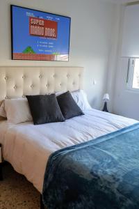 a bedroom with a large bed with a poster on the wall at Casa Belice Huelva in Huelva