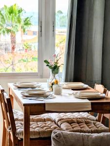 a dining room table with plates and a window at Casa Belice Huelva in Huelva