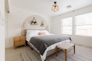 a white bedroom with a large bed and a chair at Copper Cactus House Pool, Spa, Golf! in Queen Creek +31 photos