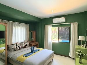 a green bedroom with a bed and a window at Yellow House Garden Pool Villa in Chiang Mai +66 photos