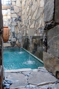 a pool of water with a waterfall in a stone wall at La Casona Del Banco Hotel Boutique in Parras de la Fuente