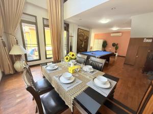 a dining room with a table and a ping pong ball at Yellow House Garden Pool Villa in Chiang Mai