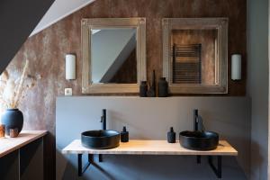 a bathroom with two sinks and a mirror at Suite Het Koetshuis in Bennekom