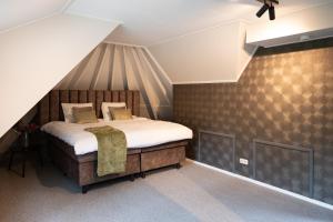 a bedroom with a bed in a attic at Suite Het Koetshuis in Bennekom