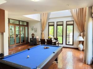 a pool table in a living room with a pool at Yellow House Garden Pool Villa in Chiang Mai