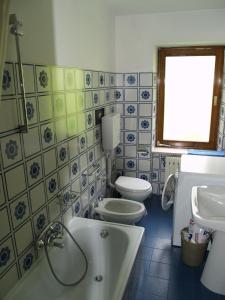 アッレゲにあるAppartamenti Katinannaのバスルーム(バスタブ、トイレ、シンク付)