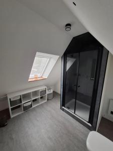 an attic room with a window and a shower at Ferienwohnung Hof Dittmer in Bleckede