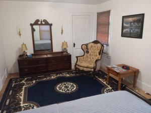 a bedroom with a dresser and a chair and a mirror at Altgeld House in South Bend